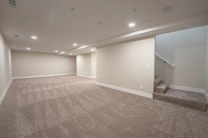 Finished basement living area with recessed lighting
