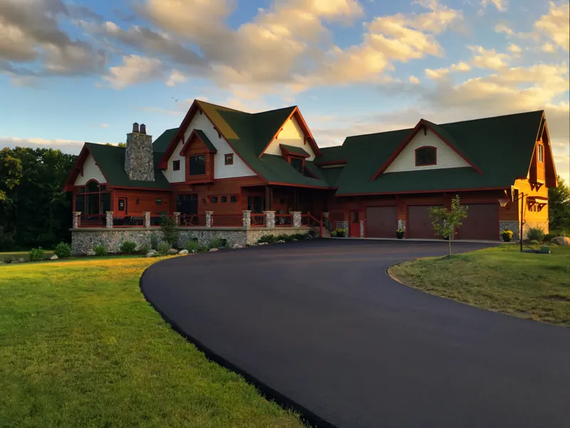 Large lake home exterior with a curved driveway