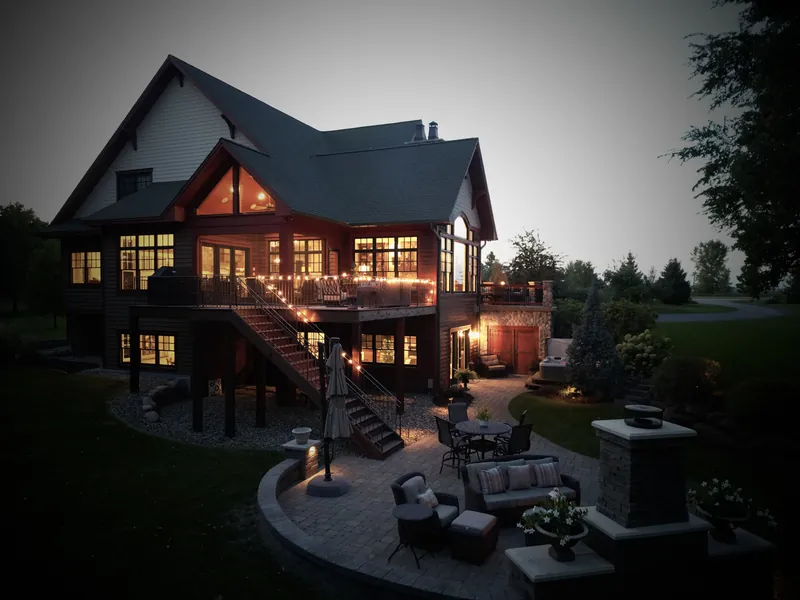 Lake home with new roof and lit decks at dusk